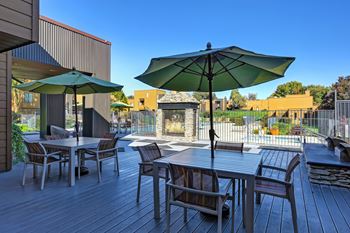 A patio with a table and chairs under an umbrella.